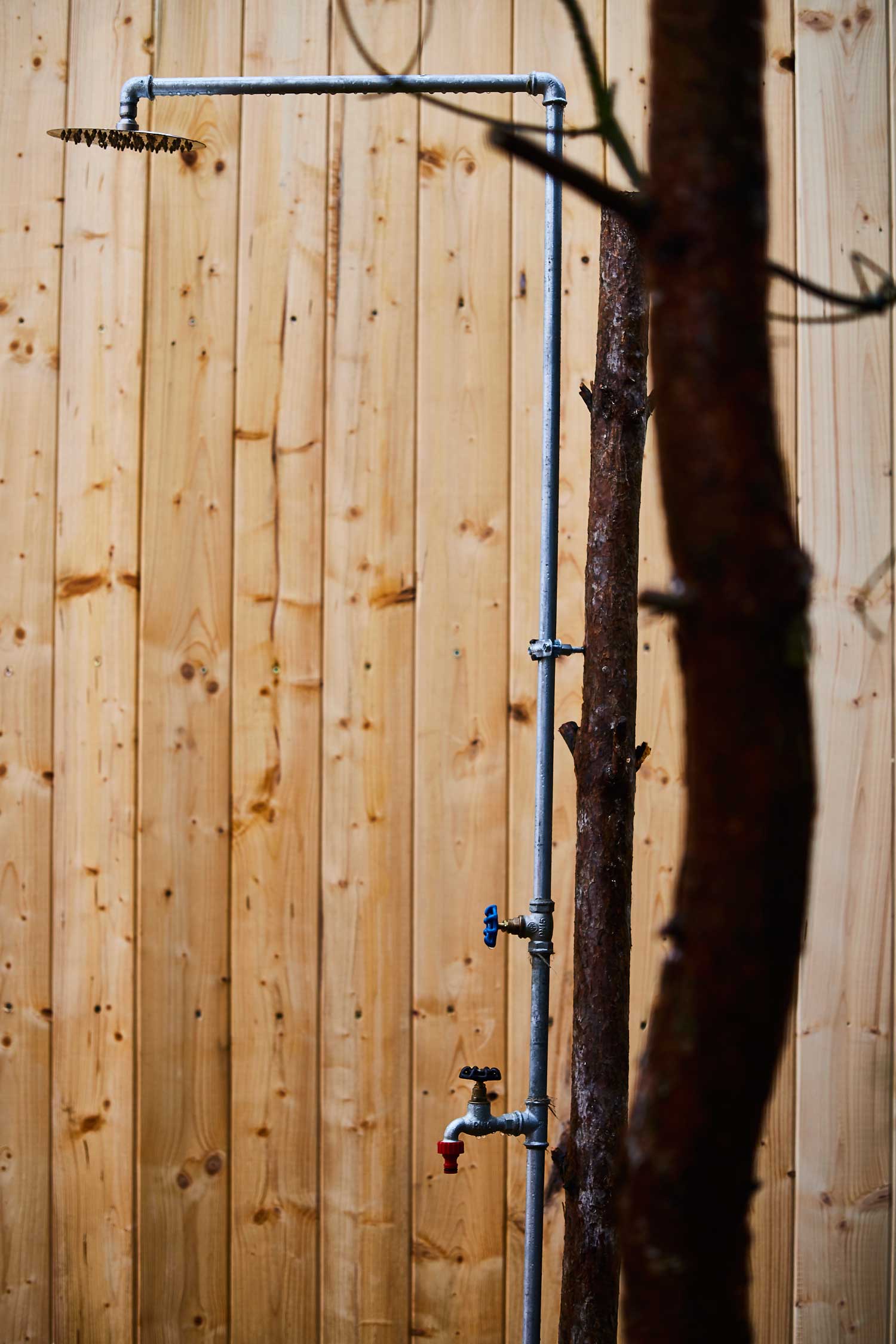 Prysznic zewnętrzny do schłodzenia po wyjściu z sauny przy domku w lesie